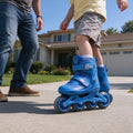 Child skating on a driveway in blue size-adjustable skates
